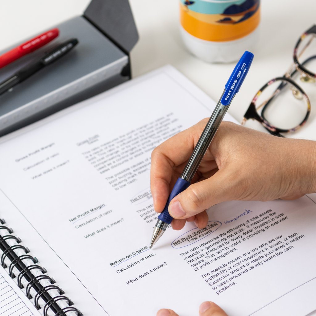 Pilot BPS-GP Ballpoint Pen with grip being used to underline important information on printed study notes.