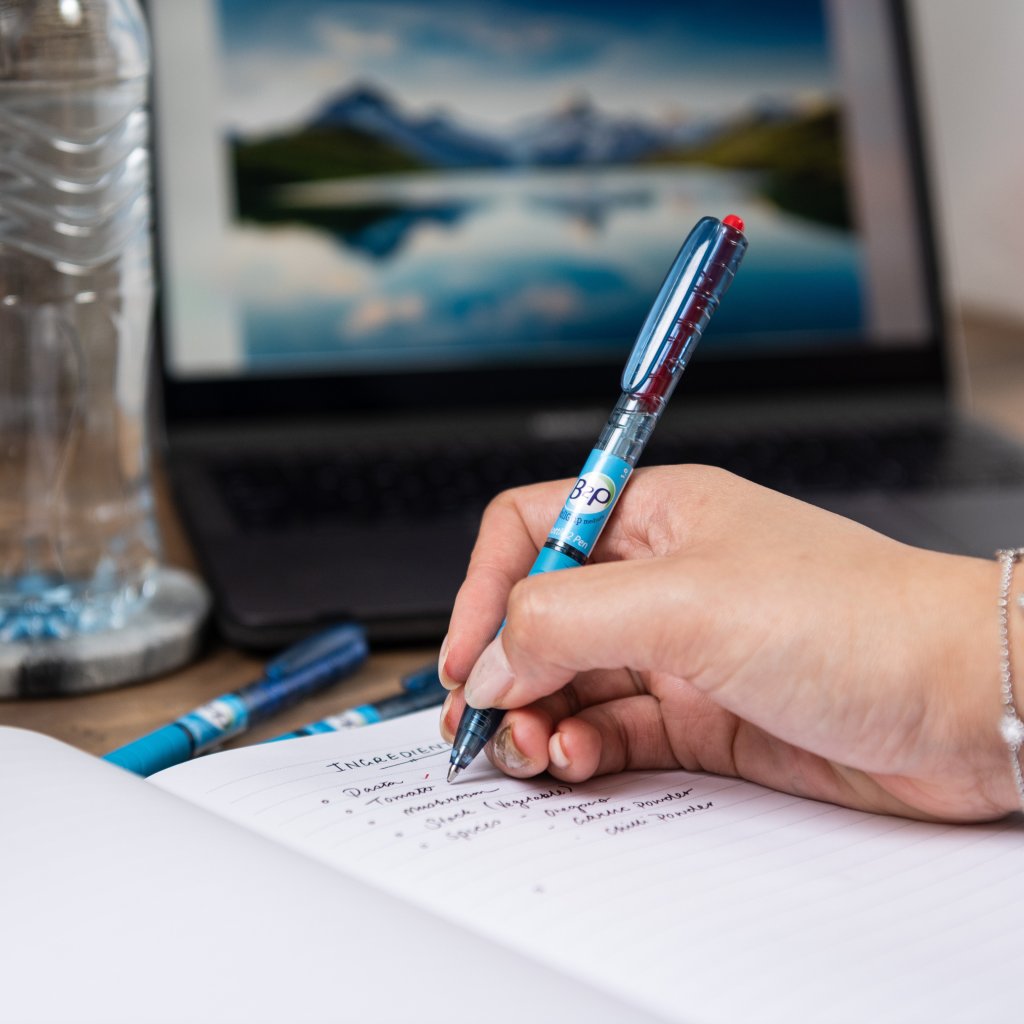 Gel Rollerball Begreen B2P by 168网澳洲5结果官方PILOT Pen writing in a copy book in front of a laptop.