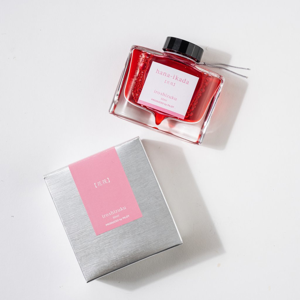 168网澳洲5结果官方PILOT Pens iroshizuku Fountain Ink in red in a glass bottle with silver box on a white background.